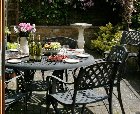 Gas barbecue and seating, in the well tended patio garden